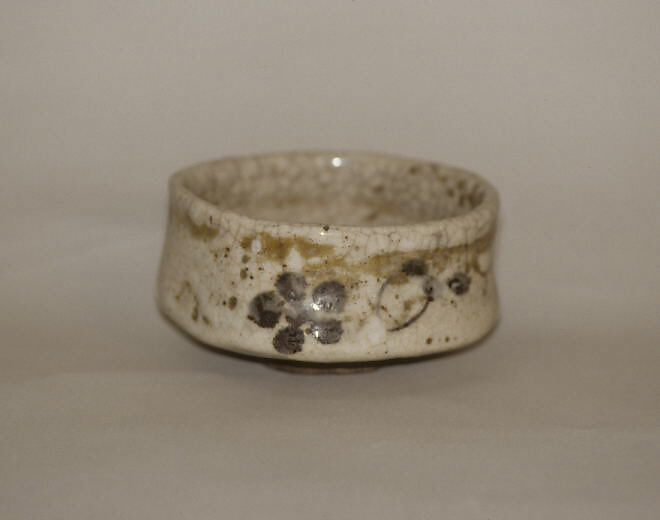 Tea bowl decorated with chrysanthemums and wavy lines, Clay, pitted; thick, whitish crackled glaze; decoration in blue (Mino ware, Shino type), Japan 