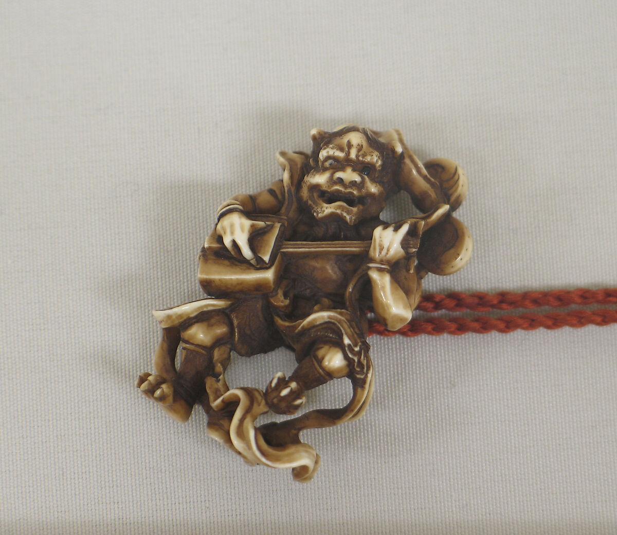 Inrō with Birds, Plum, Chrysanthemum, and Loquat, Gold lacquer ground with mother-of-pearl, coral, and stained ivory inlay in Shibayama style
Netsuke: thunder god playing samisen; carved ivory
Ojime: cylinder with asters in openwork, Japan