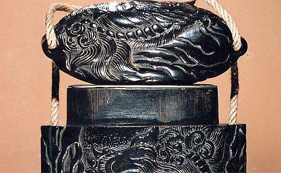 Case (Inrō) with Design of Shishi Dog Jumping and Climbing among Rocks and Bamboo, Wood, ebony, carved relief; Interior: plain & silver metal lining, Japan