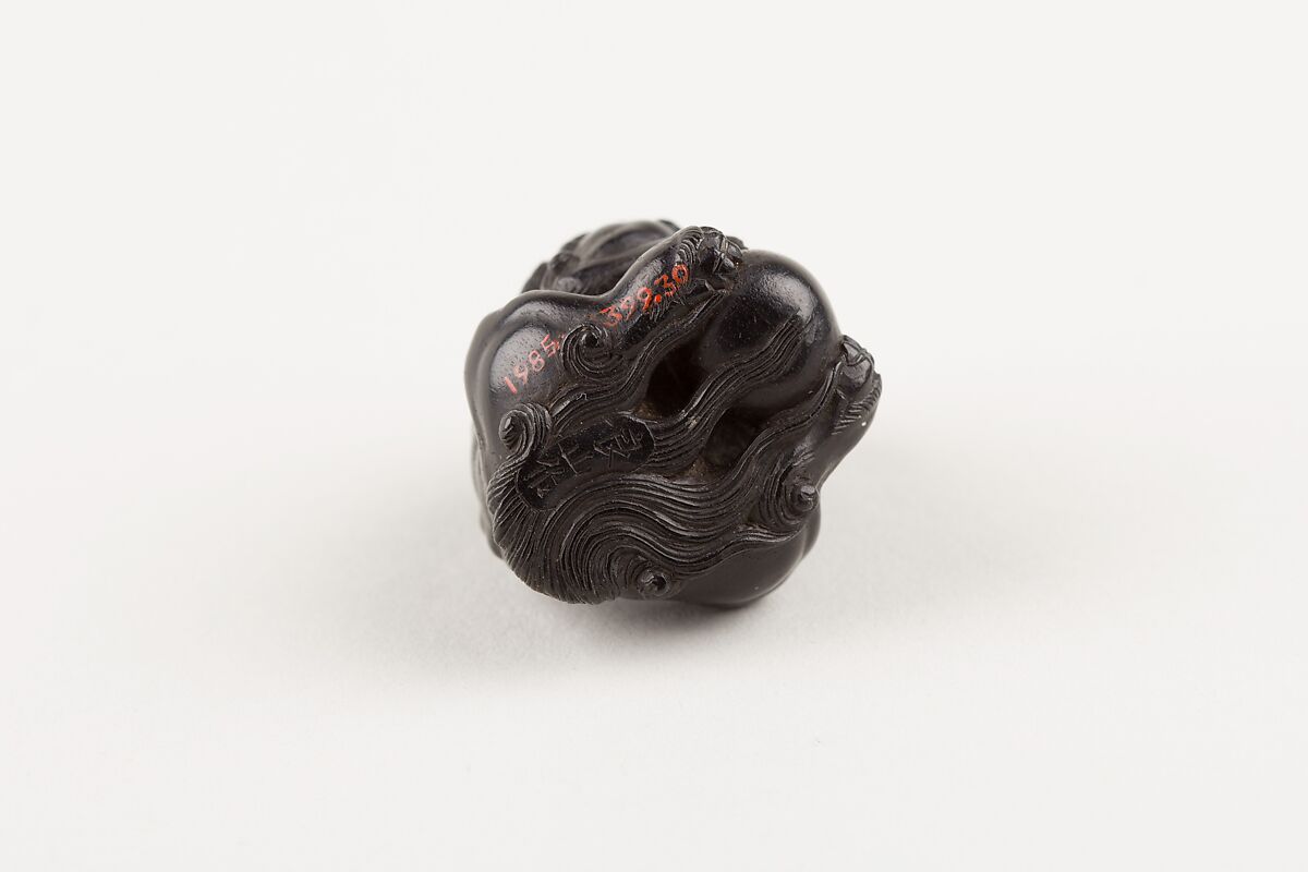 Netsuke of Seated Shishi Clutching a Ball, Ryōzan (Japanese), Ebony with gold and horn inlay, Japan