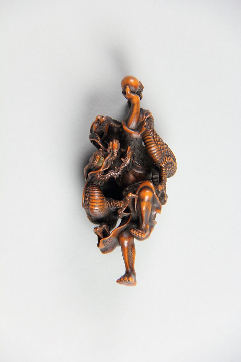 Netsuke of Dragon Coiled around the Body of a Man, Wood; inlaid glass eyes, Japan 