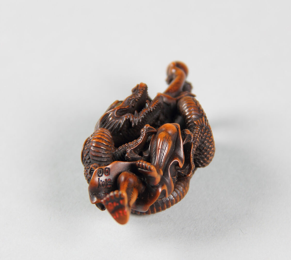 Netsuke of Dragon Coiled around the Body of a Man, Wood; inlaid glass eyes, Japan