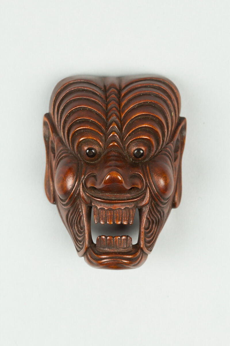 Netsuke of Mask, Wood; dark brown, inlaid eyes, Japan 