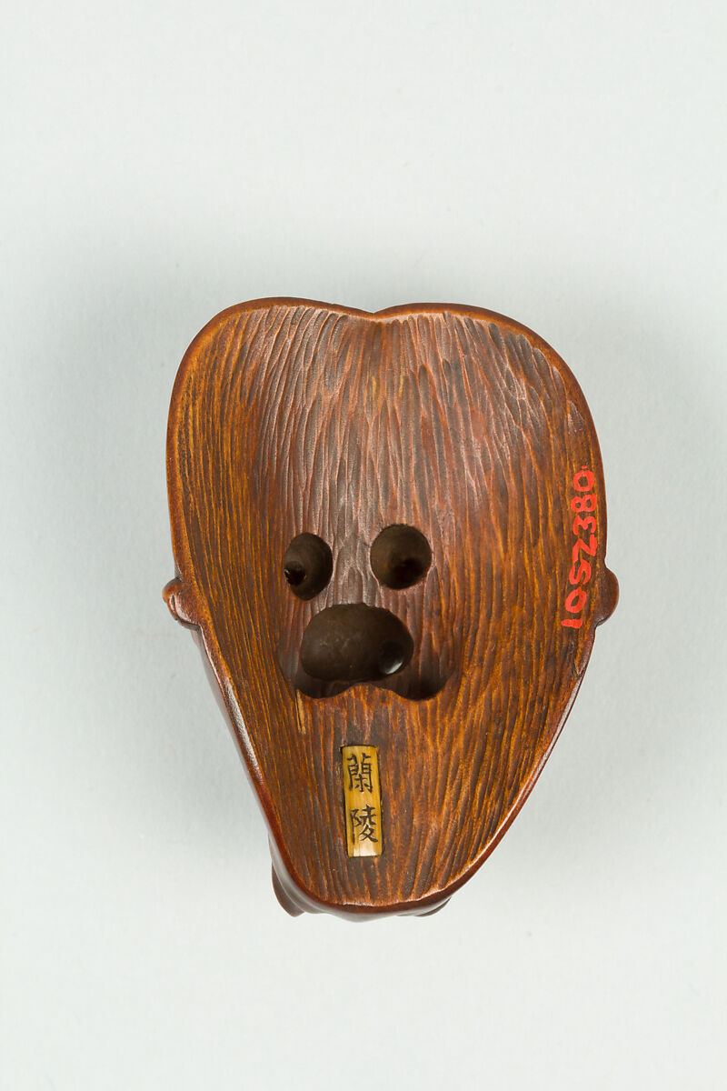 Netsuke of Mask, Wood; dark brown, inlaid eyes, Japan