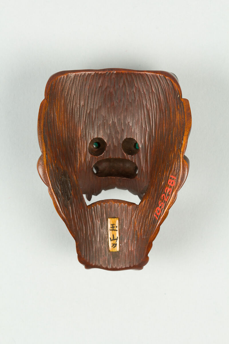 Netsuke of Devil Mask with Wide-Open Mouth, Wood, dark brown; inlaid green glass eyes, Japan