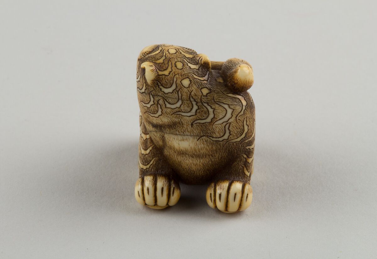 Netsuke of Seated Tiger with a Curled-up Tail Across its Back, Ivory, horn, Japan