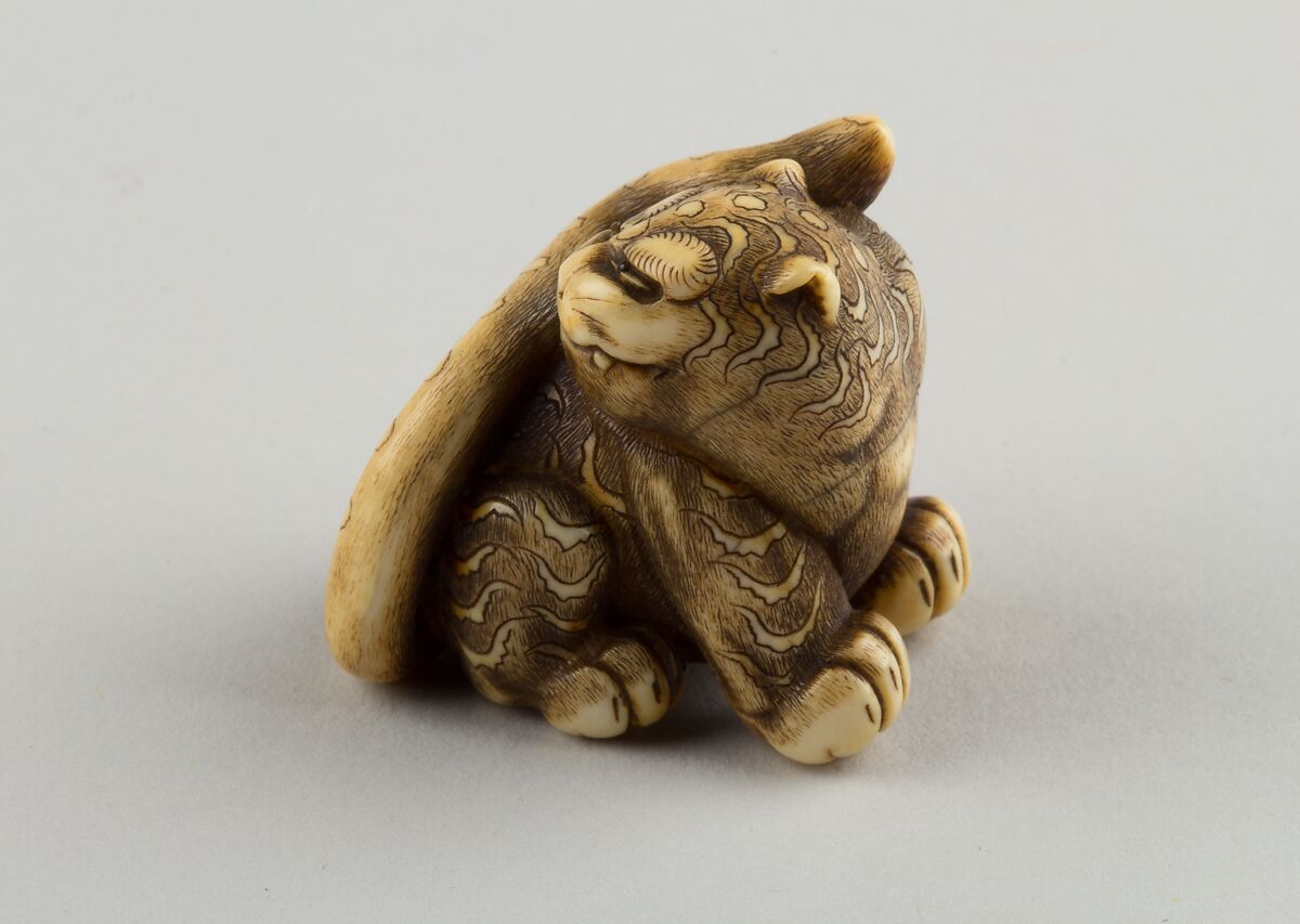 Netsuke of Seated Tiger with a Curled-up Tail Across its Back, Ivory, horn, Japan