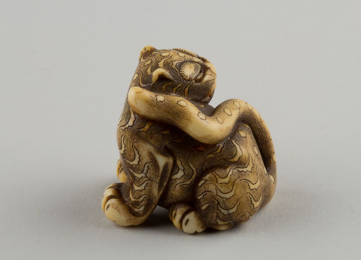 Netsuke of Seated Tiger with a Curled-up Tail Across its Back, Ivory, horn, Japan