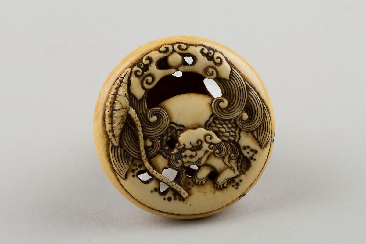 Netsuke Carved with Shishi; reverse with Lotus Leaf, Attributed to Rensai, Ivory, Japan 