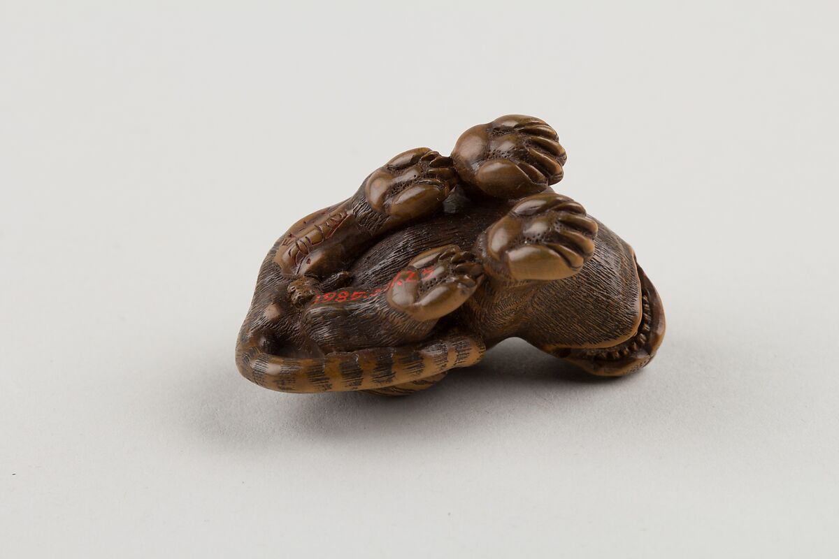 Netsuke of Seated Tiger with Tail Curled beside Him, Minkō (Japanese, ca. 1735–1816), Wood; brass and horn inlay, Japan