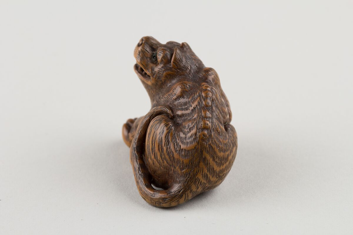 Netsuke of Seated Tiger with Tail Curled beside Him, Minkō (Japanese, ca. 1735–1816), Wood; brass and horn inlay, Japan