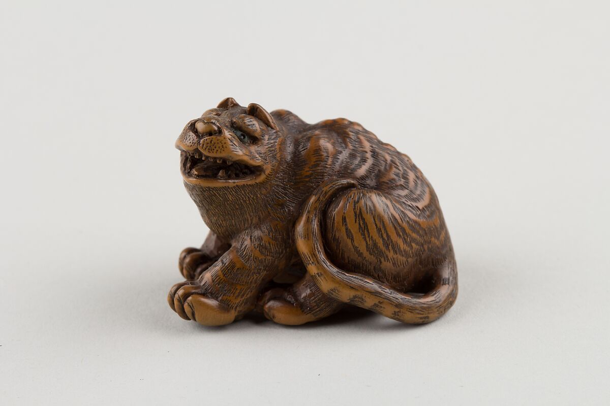 Netsuke of Seated Tiger with Tail Curled beside Him, Minkō (Japanese, ca. 1735–1816), Wood; brass and horn inlay, Japan 