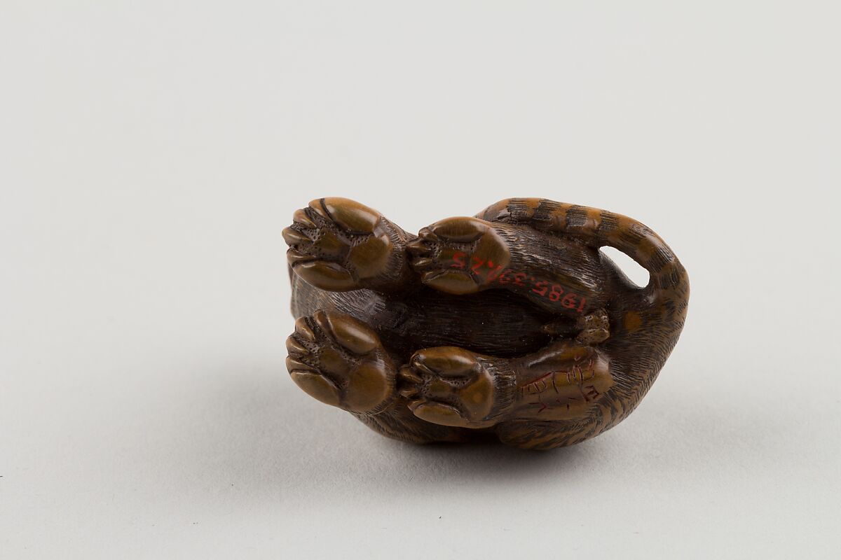 Netsuke of Seated Tiger with Tail Curled beside Him, Minkō (Japanese, ca. 1735–1816), Wood; brass and horn inlay, Japan