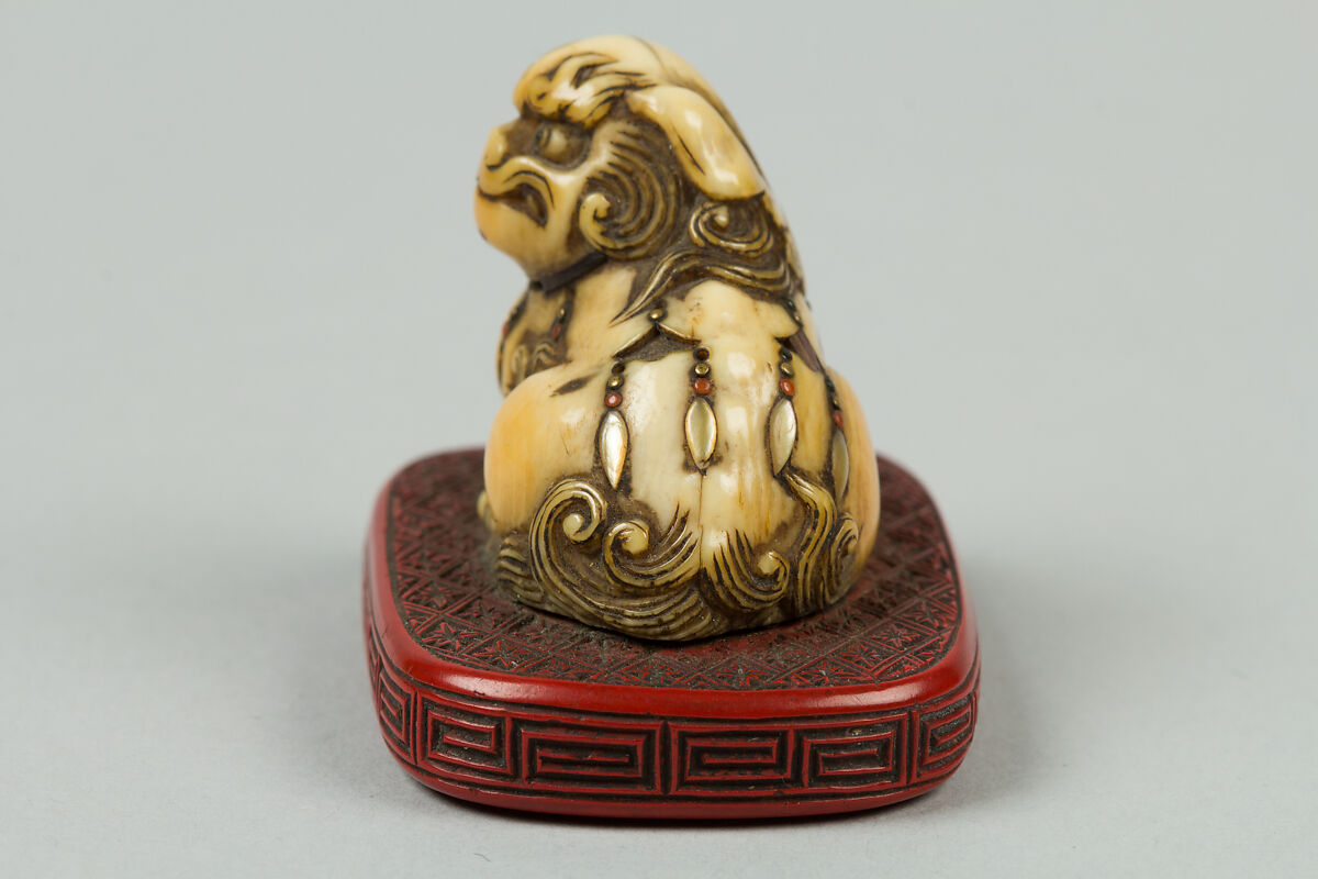 Netsuke of Qilin Sitting on a Nest, Ivory, red lacquer, Japan