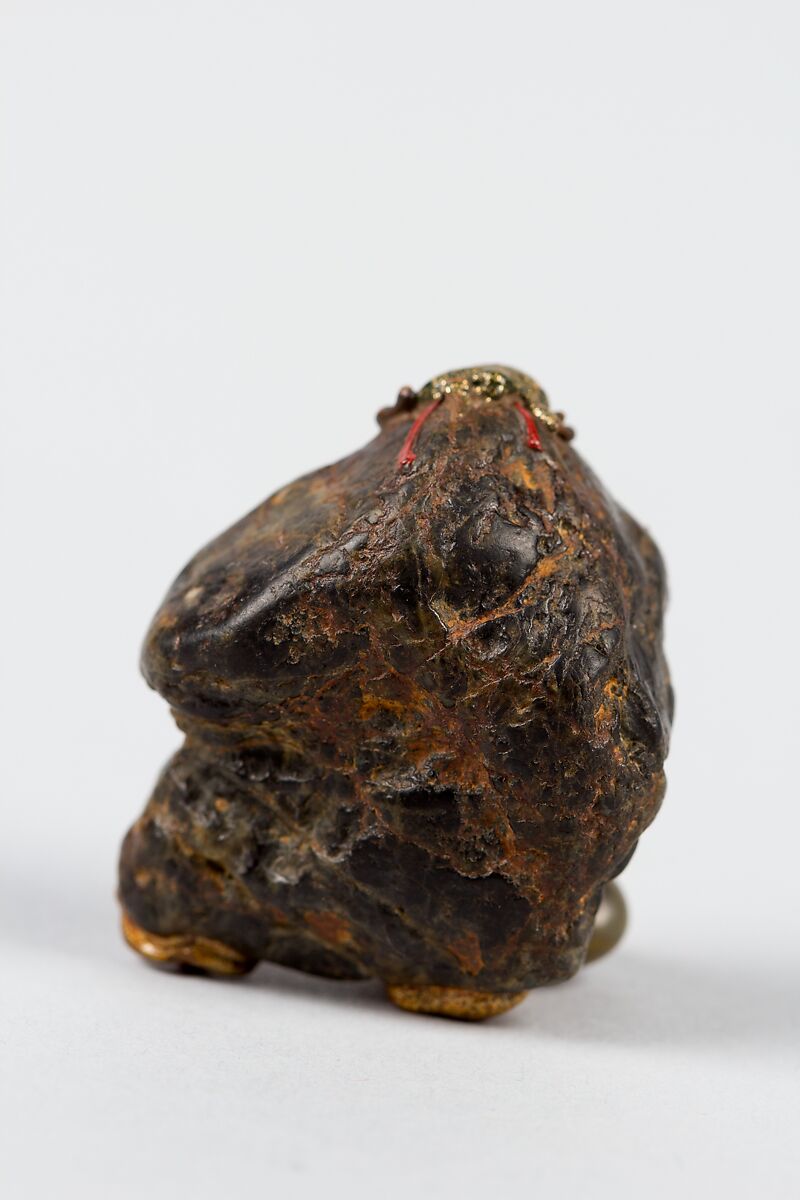 Netsuke, Stone ornamented with gilt and red enamel-inlaid metal eyes, Japan