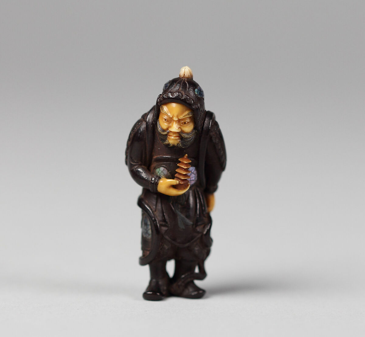 Netsuke of Bishamon, Black wood with ivory face and hands and inlaid ornamentation, Japan 