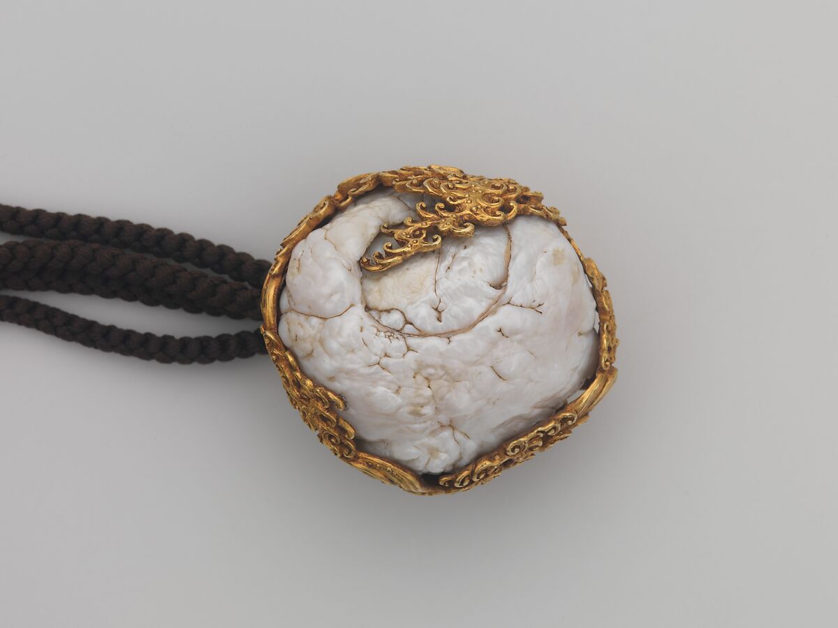 Tobacco Pouch and Pipe with Netsuke of Freshwater Pearl in Gold Mount, Pouch: Dutch embossed leather with silver foil, and color
Clasp: gold, shakudō and shibuichi
Ojime: gold
Netsuke: freshwater pearl and gold
Pipe: metal
Pipe case: Dutch embossed leather with silver foils, and color, Japan