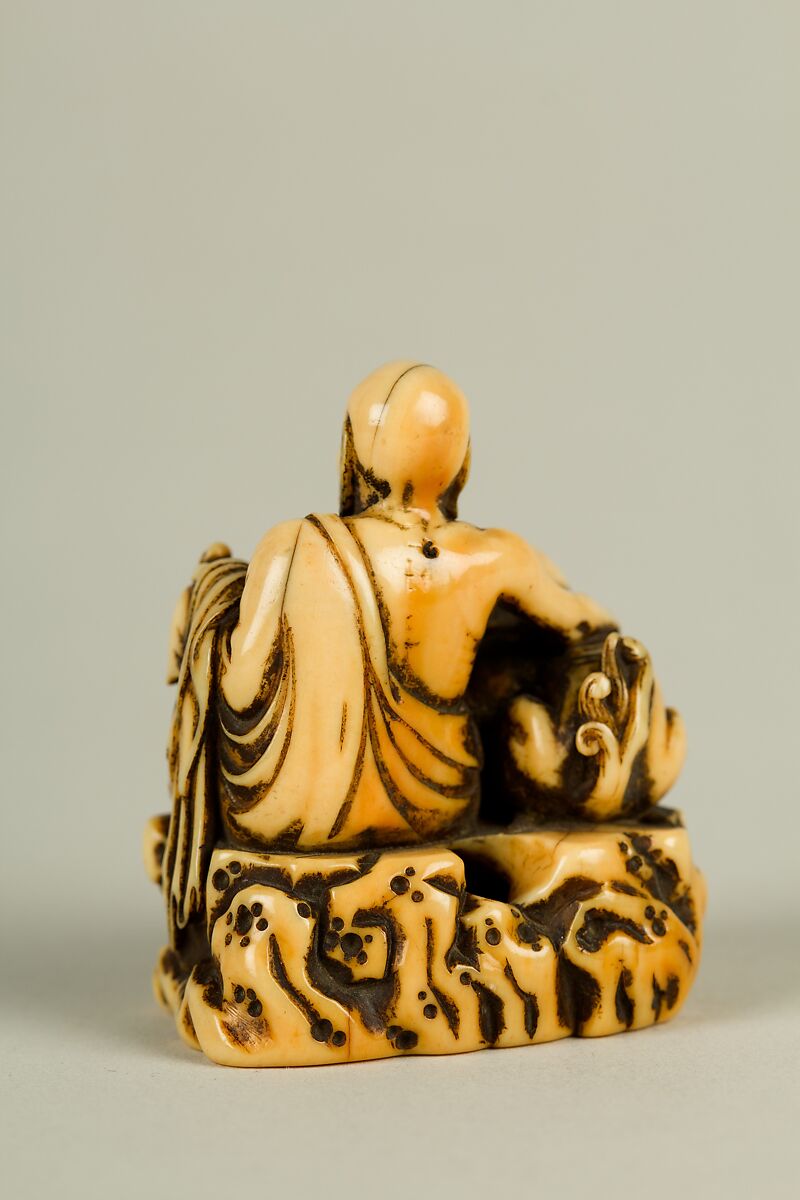 Netsuke of Man and a Qilin Sitting on a Rock, Ivory, Japan