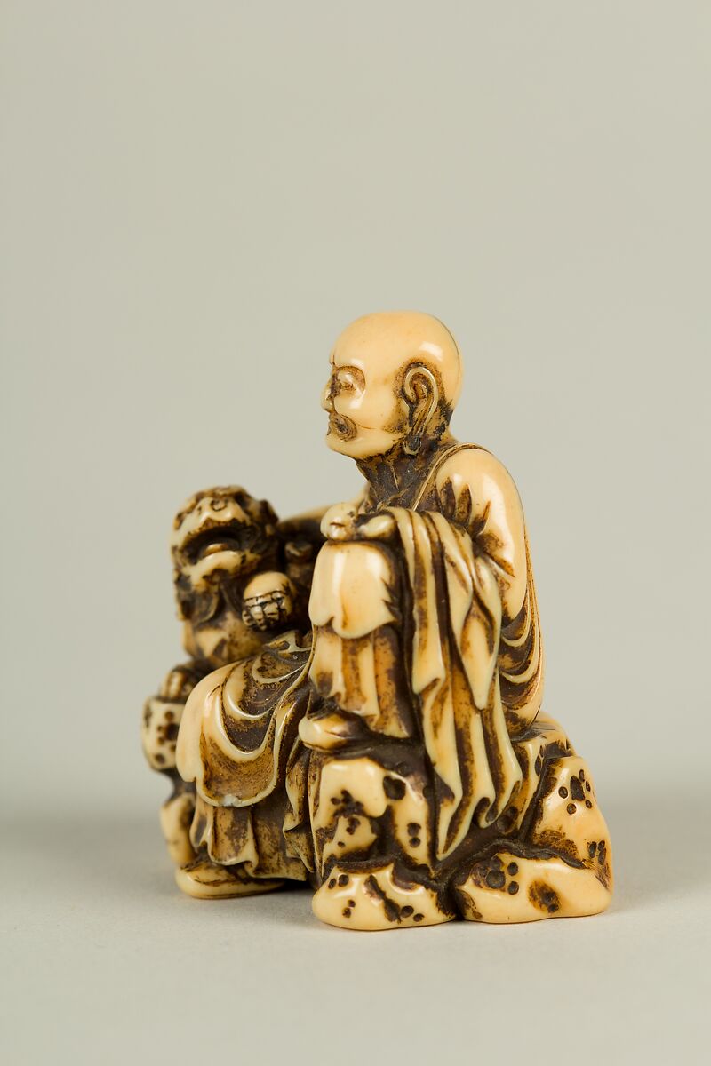 Netsuke of Man and a Qilin Sitting on a Rock, Ivory, Japan