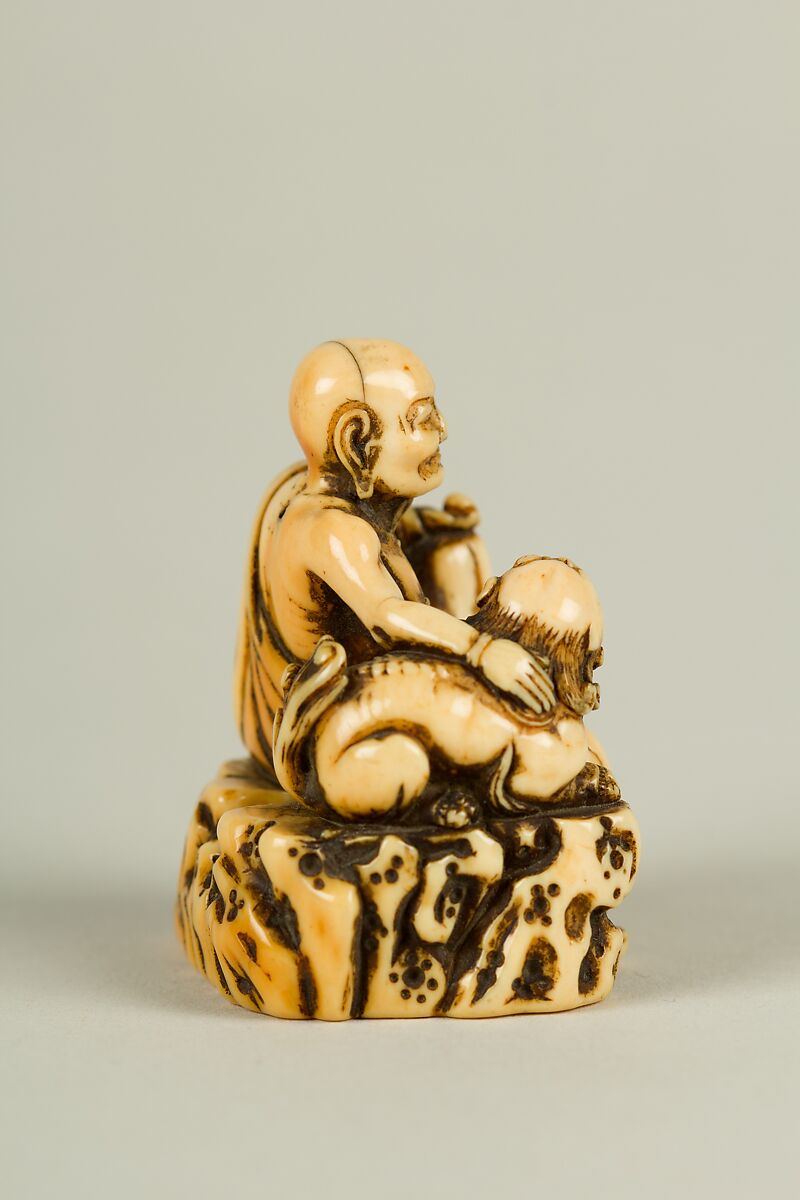Netsuke of Man and a Qilin Sitting on a Rock, Ivory, Japan