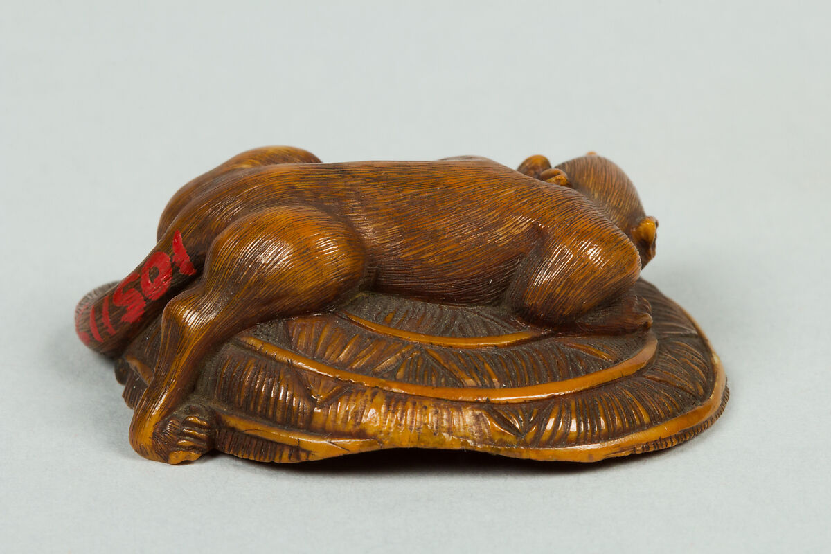 Netsuke of Animal on a Straw Mat under which is a Mouse, Ivory, Japan