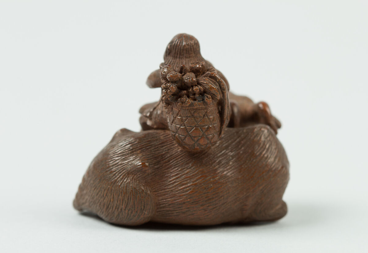 Netsuke of Man Playing Flute atop an Ox, Wood, Japan