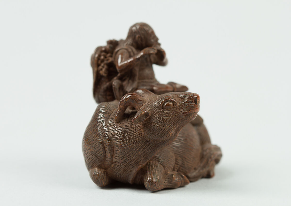 Netsuke of Man Playing Flute atop an Ox, Wood, Japan