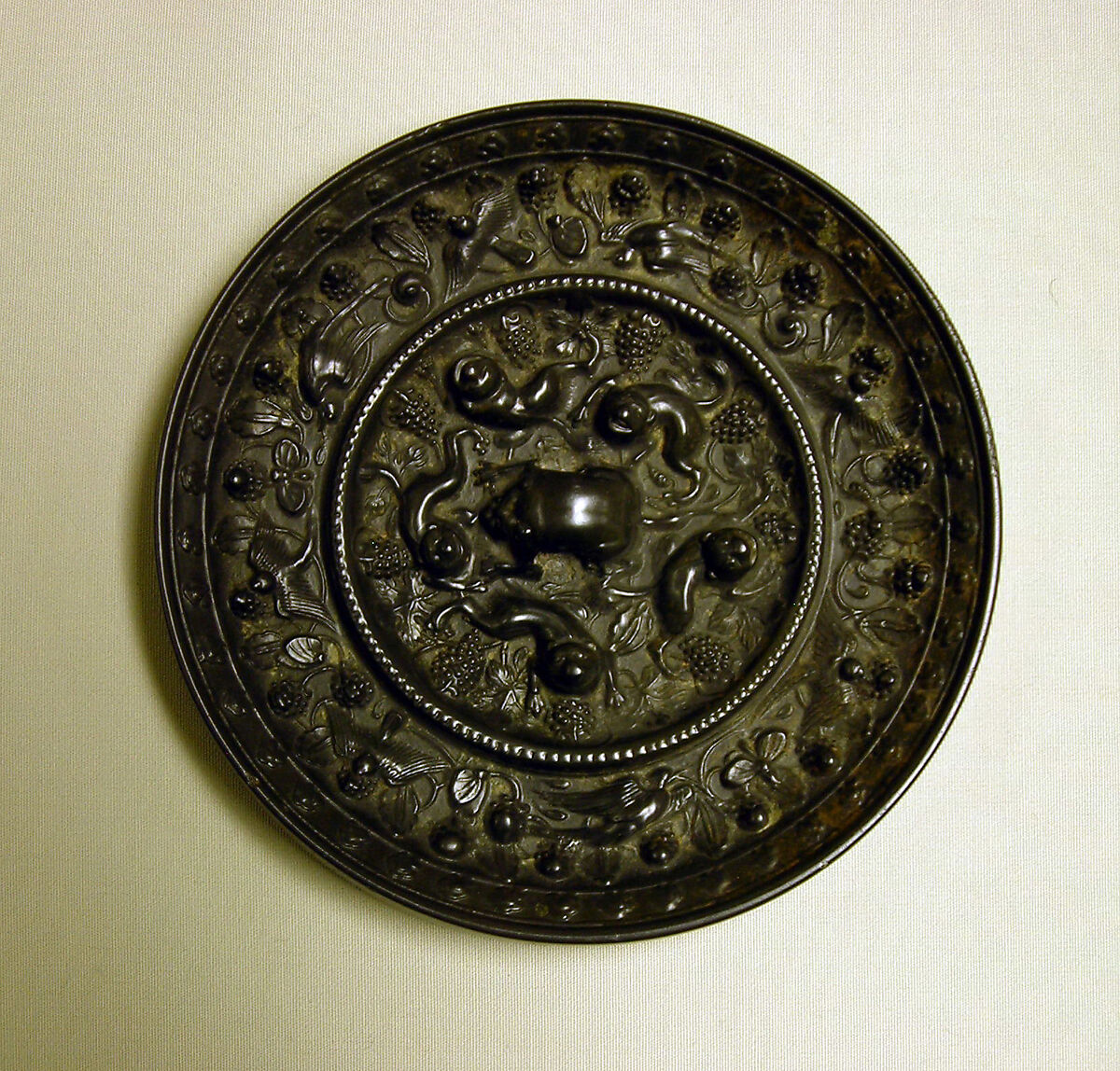 Mirror with fantastic animals amid grape vines, Bronze with black patina, China 