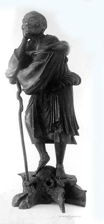 Statuette of Old Man Dressed in Short Draped Garments and Sandals, Carries a Bundle Tied over His Shoulder and Leans on a Staff, Wood, Japan 