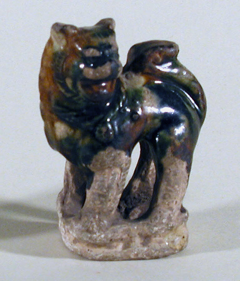 Lion, Molded white clay covered with mottled brown, green and blue three color (sancai) glaze, China 