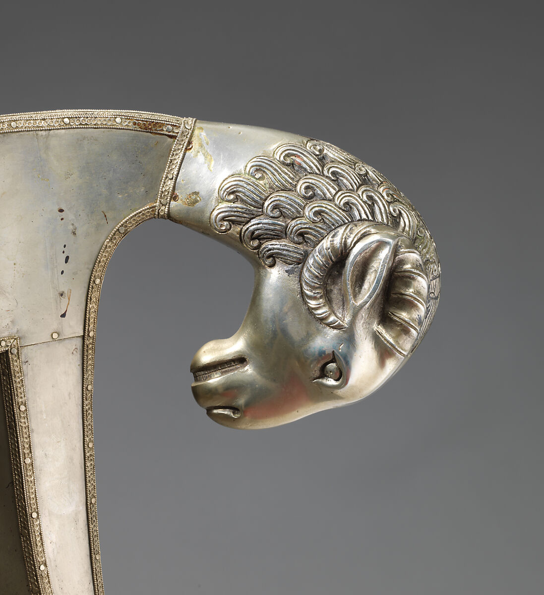 Side chair with rams' heads (one of a pair), White alloy metal sheets (silvered?) over wooden core, probaly teak; silk and metallic woven textile, Anglo-Indian