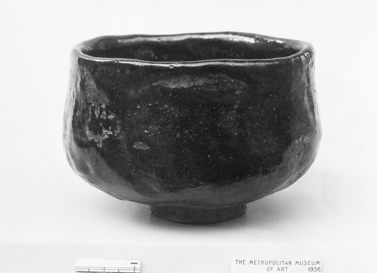 Teabowl, Uneven lip, slightly bulging sides, small unglazed foot; light brown clay, brown and black glaze; inside, large splash of red glaze (Raku ware), Japan 