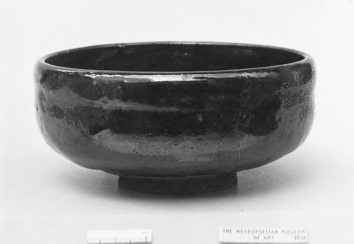Teabowl, Kichizaemon, Shallow, curved to small foot; dark gray clay; brilliant black glaze having three large splashes of dull red (Raku ware), Japan 