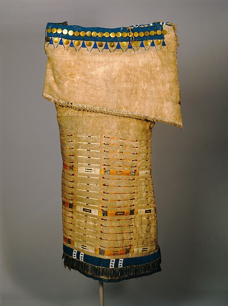 Woman’s Side-Fold Dress, Native-tanned leather, porcupine and bird quills, brass buttons, cowrie shells, glass beads, metal cones, horsehair, plant fiber, woven cotton tape, wool cloth, Probably Lakota or Cheyenne 