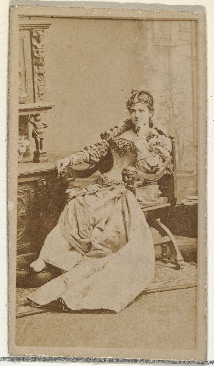 [Actress in studio reclining in heavy wooden chair], from the Actors and Actresses series (N145-8) issued by Duke Sons & Co. to promote Duke Cigarettes, Issued by W. Duke, Sons &amp; Co. (New York and Durham, N.C.), Albumen photograph 