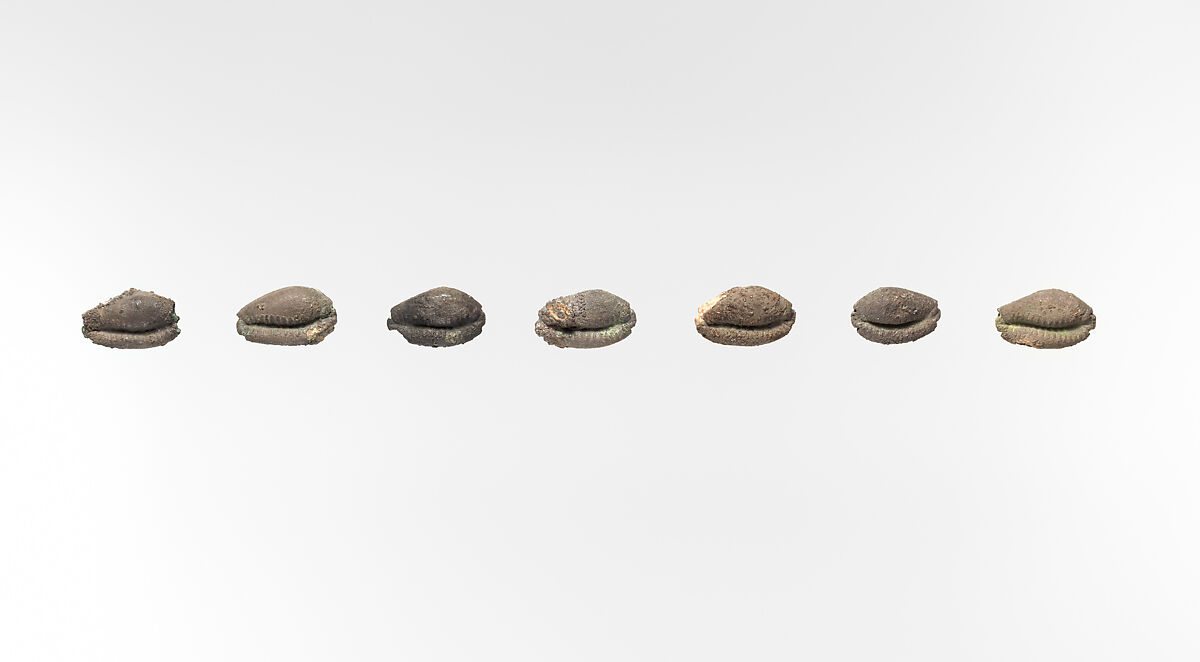 Seven beads in the shape of cowrie shells, Silver