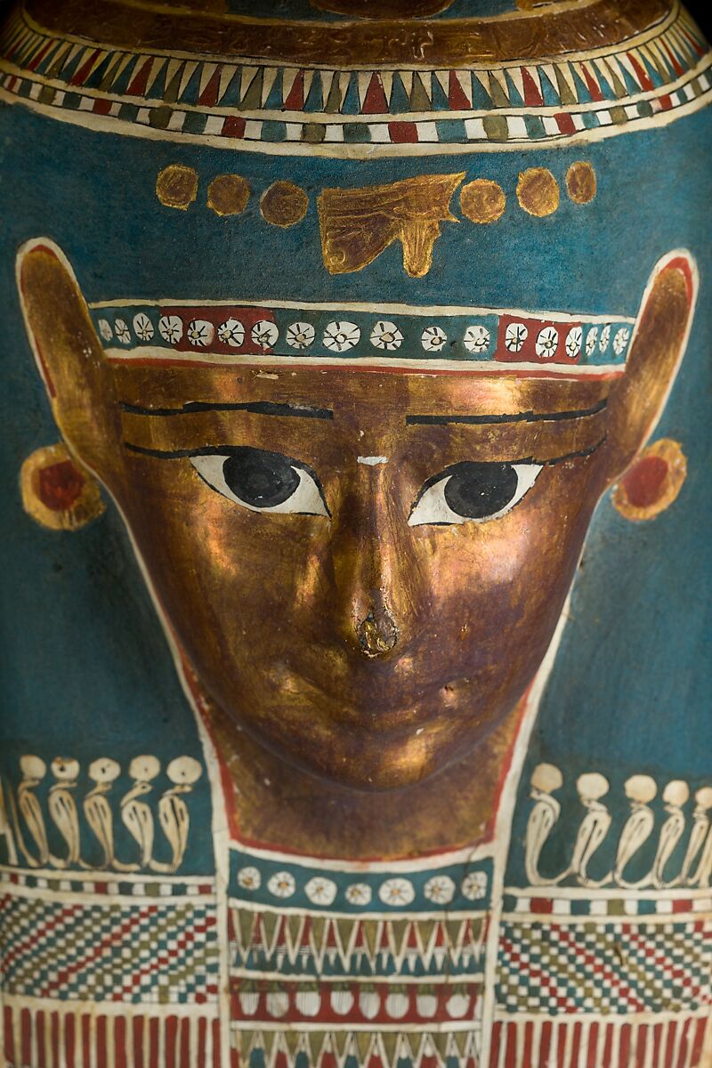 Mummy of Tasheriteniset with mummy mask and other cartonnage elements, also with garland of plants, Mummified human body, linen, mummification material, painted and gilded cartonnage, plant remains