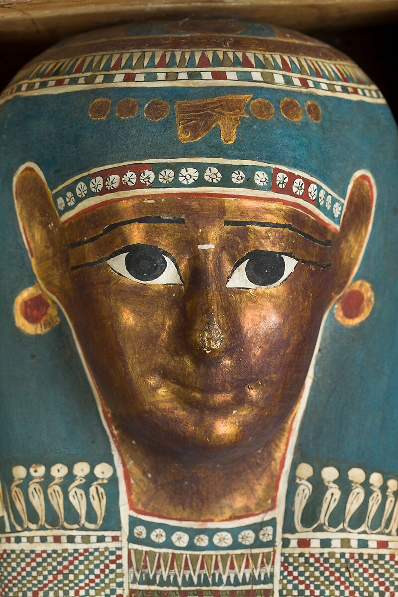 Mummy of Tasheriteniset with mummy mask and other cartonnage elements, also with garland of plants, Mummified human body, linen, mummification material, painted and gilded cartonnage, plant remains