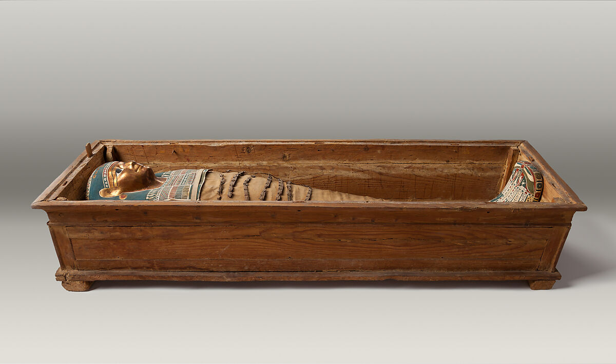 Mummy of Tasheriteniset with mummy mask and other cartonnage elements, also with garland of plants, Mummified human body, linen, mummification material, painted and gilded cartonnage, plant remains