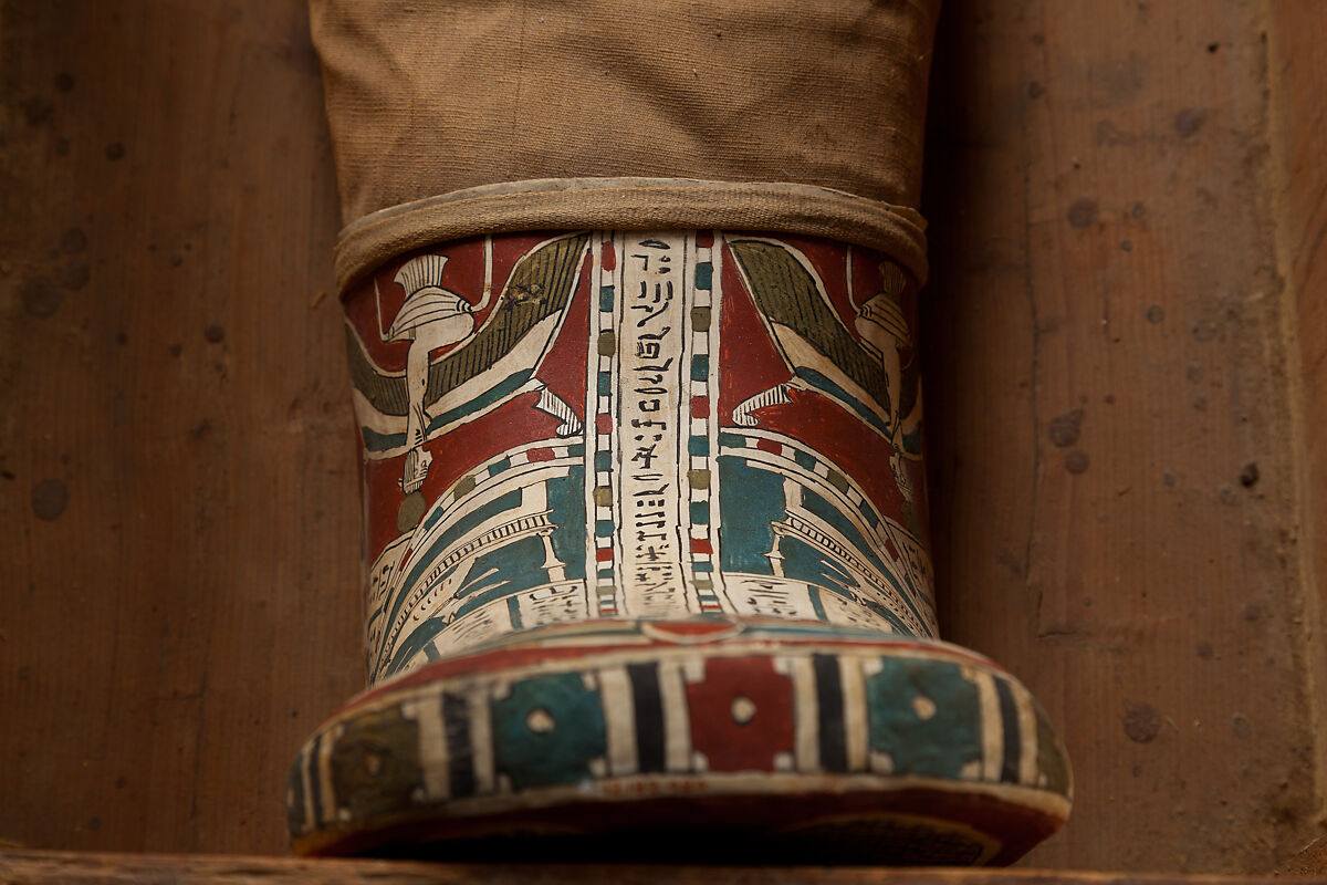 Mummy of Tasheriteniset with mummy mask and other cartonnage elements, also with garland of plants, Mummified human body, linen, mummification material, painted and gilded cartonnage, plant remains