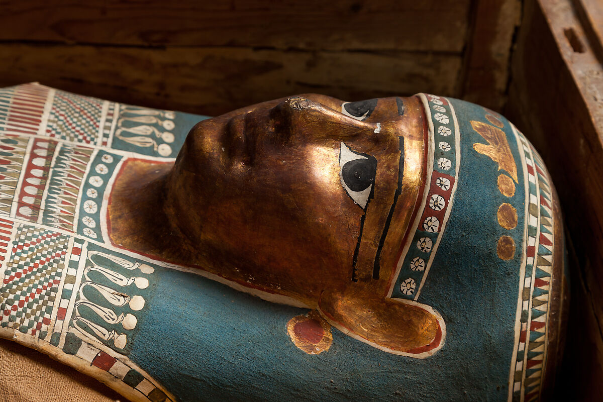 Mummy of Tasheriteniset with mummy mask and other cartonnage elements, also with garland of plants, Mummified human body, linen, mummification material, painted and gilded cartonnage, plant remains