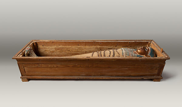 Mummy of Tasheriteniset with mummy mask and other cartonnage elements, also with garland of plants