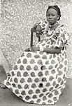 Young Woman Seated in Apple Print Dress