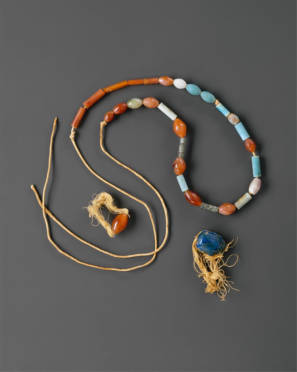 Rings and necklace, Carnelian and linen thread; blue-glazed steatite and linen thread; carnelian, turquoise, moss agate, amethyst, milky quartz, green-glazed steatite, and twisted linen cord 