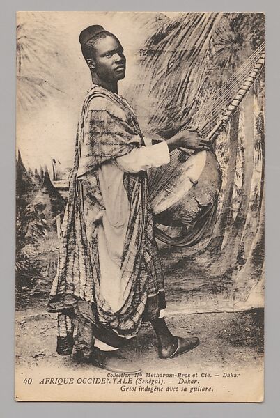 West Africa (Senegal) Dakar—Native griot with his guitar [Afrique Occidentale (Sénégal) Dakar—Griot indigène avec sa guitare], Louis Hostalier (Senegal)  French, Postcard format photomechanical reproduction published by Metharam Bros. et Cie. Dakar