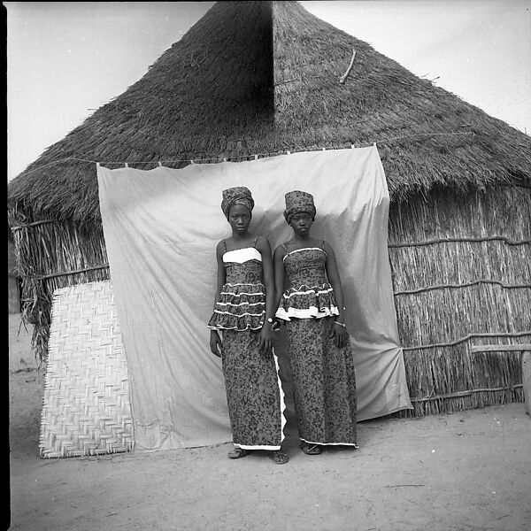 Two Women in Front of a Thatch-Roof House, Oumar Ka (Senegalese, 1930–2020 Touba, Senegal) 