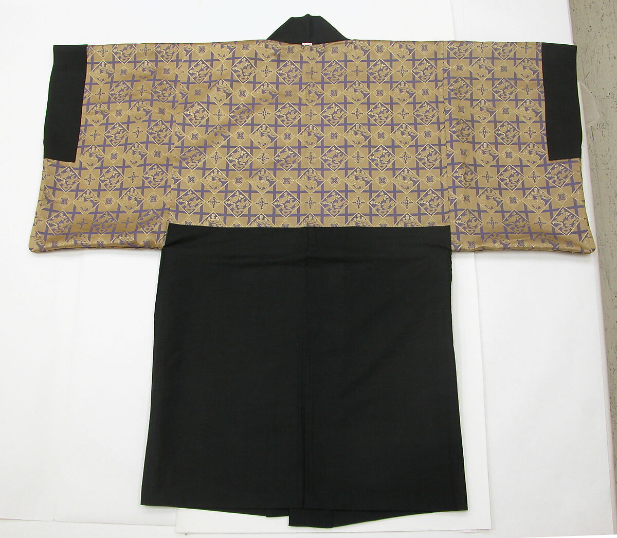 Costume of a Japanese Gentleman, (a) Silk,metalic thread / Plain weave
(b) Silk / Plain weave
(c) Silk / Plain weave
(d) Cotton; Silk / Plain weave
(e) Silk / Plain weave
(f) Silk / Braided
(g) Straw, leather / Woven
(h) Straw, leather / Woven
(i) Rush; leather; silk; wood / Woven
(j) Rush; leather; silk; wood / Woven
(k) Cotton / Knit
(l) Cotton / Knit, Japan