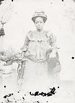 Woman in studio with headtie and dutch wax Victorian-style dress