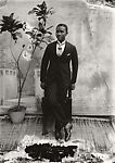 Young man in cravat with potted plant, Alex Agbaglo Acolatse (Togolese, Kedzi 1880–1975 Lomé), Gelatin silver print