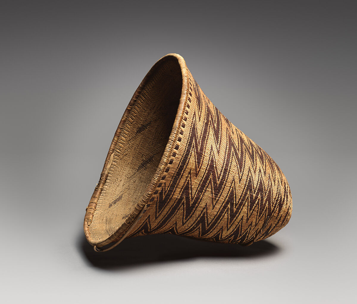 Diagonally twined carrying basket, Willow shoot foundation, sedge root warp, redbud shoot weft, coiled-on oak rim rod and split wild grape vine rim wrap, Pomo, Native American